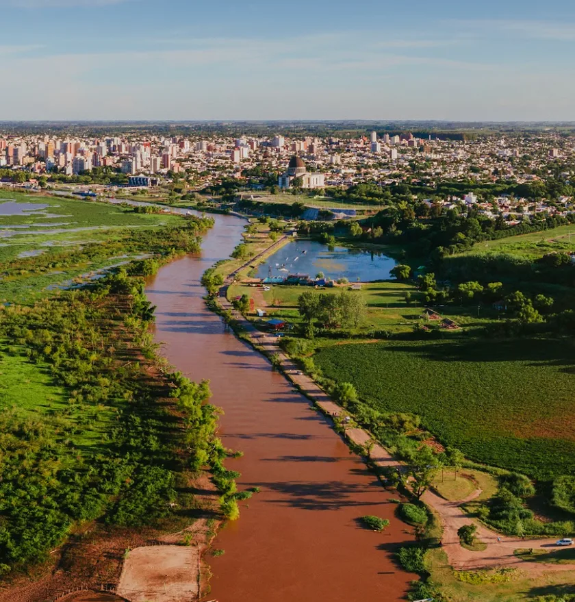 Vista aérea de San Nicolás de los Arroyos con el río Paraná y el Eco Parque levantado sobre el antiguo basural municipal