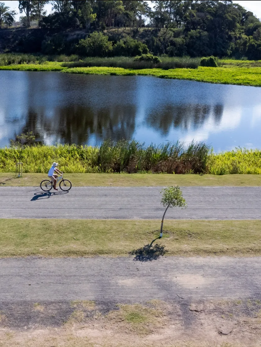 Ciclista en el paseo del Eco Parque de San Nicolás de los Arroyos, junto a una de sus cuatro lagunas