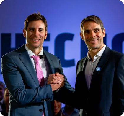 Santiago y Manuel Passaglia dándose la mano en un acto de HECHOS en San Nicolás de los Arroyos